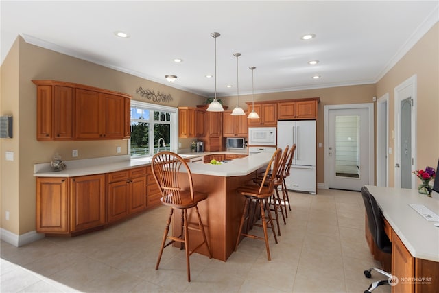 kitchen with a breakfast bar area, white appliances, light tile patterned floors, a kitchen island, and decorative light fixtures