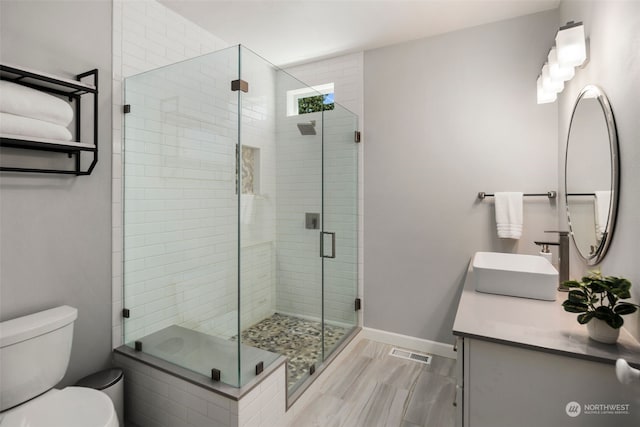 bathroom featuring vanity, toilet, and an enclosed shower