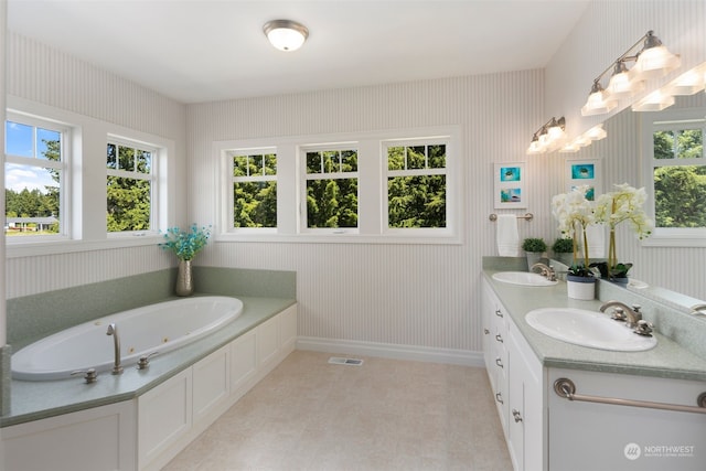 bathroom with tile patterned floors, a bath, a wealth of natural light, and double sink vanity