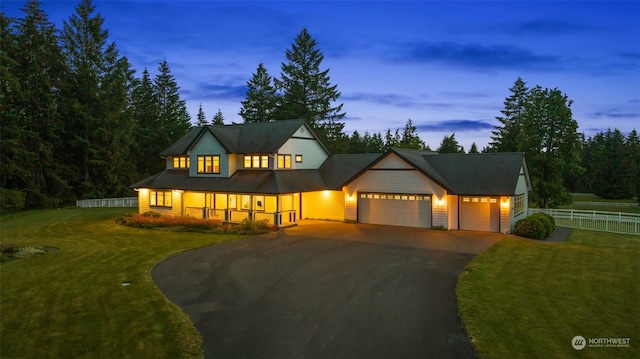 modern inspired farmhouse with a garage and a lawn