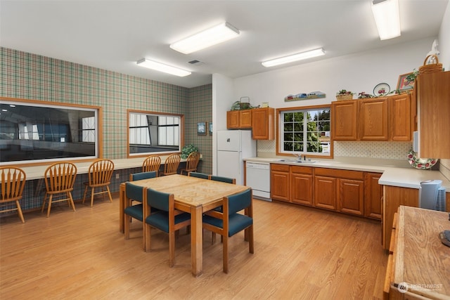 kitchen with backsplash, light hardwood / wood-style flooring, white appliances, and sink