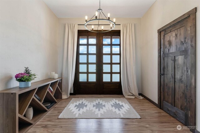 foyer entrance featuring a chandelier, french doors, and hardwood / wood-style floors