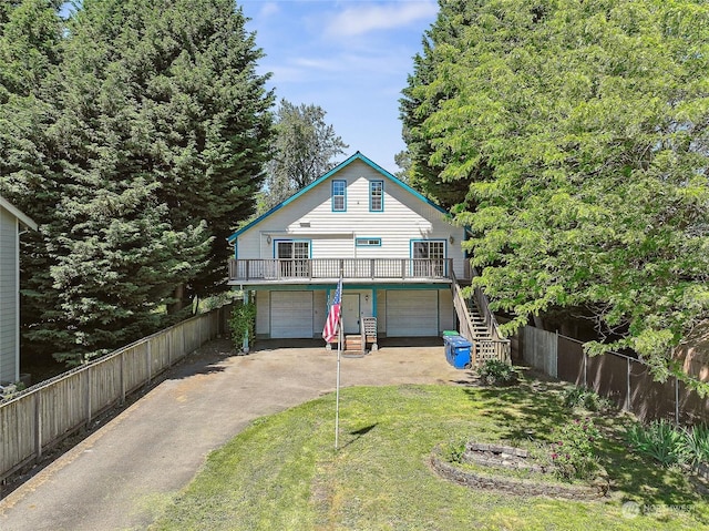 exterior space featuring a wooden deck, a yard, and a garage