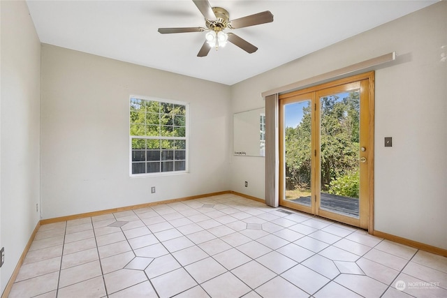 empty room featuring ceiling fan, light tile patterned flooring, and a wealth of natural light