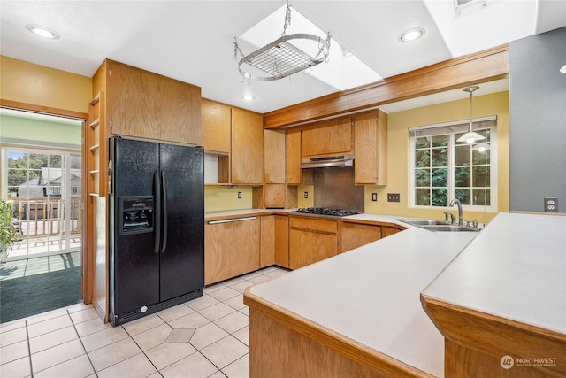 kitchen with pendant lighting, sink, tasteful backsplash, black fridge with ice dispenser, and kitchen peninsula