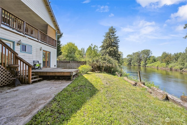 view of yard with a deck with water view