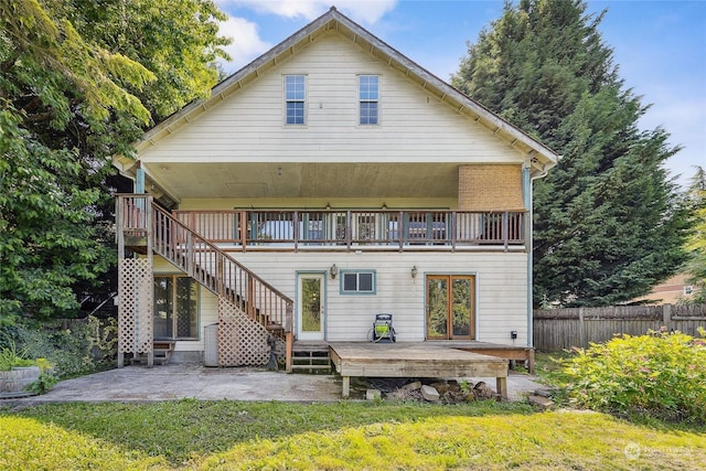 back of house featuring a lawn, french doors, a patio, and a deck