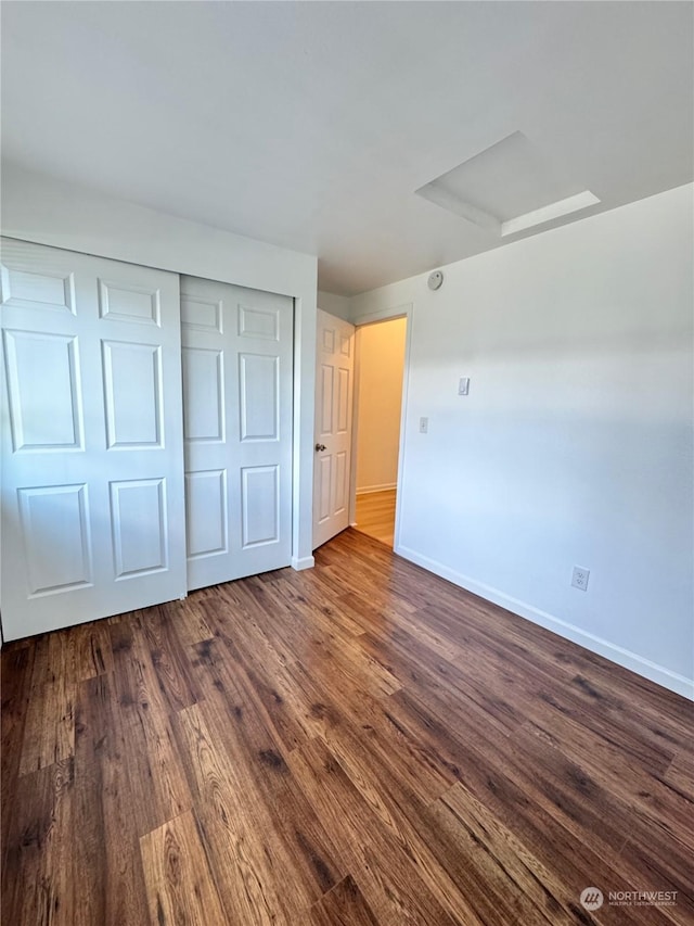 unfurnished bedroom featuring dark hardwood / wood-style floors and a closet