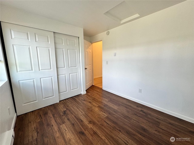 unfurnished bedroom featuring dark hardwood / wood-style flooring and a closet