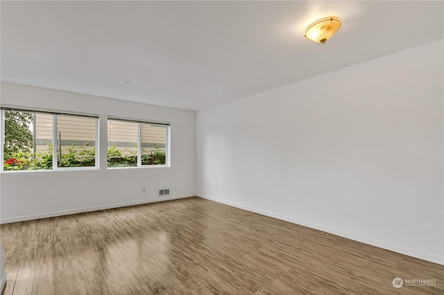 empty room with hardwood / wood-style flooring