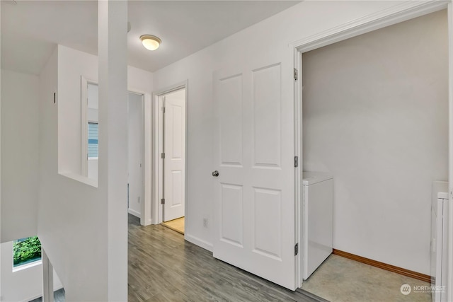 hallway with washer and dryer and hardwood / wood-style flooring