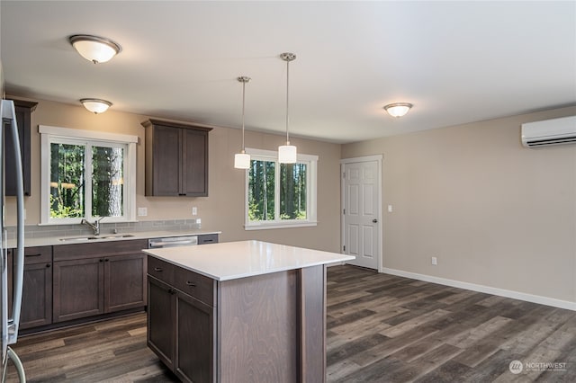 kitchen with a center island, dark hardwood / wood-style flooring, dark brown cabinets, decorative light fixtures, and sink