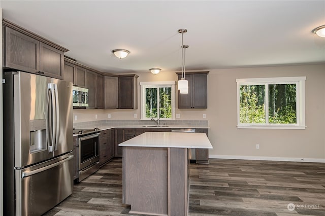 kitchen featuring a center island, dark wood-type flooring, appliances with stainless steel finishes, pendant lighting, and sink