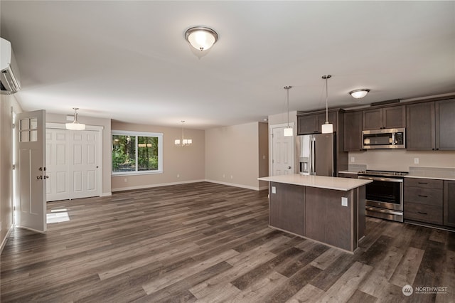 kitchen featuring hanging light fixtures, dark wood-type flooring, appliances with stainless steel finishes, and a kitchen island