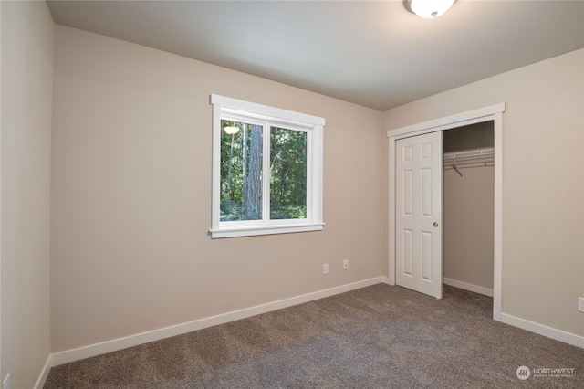 unfurnished bedroom featuring a closet and dark colored carpet