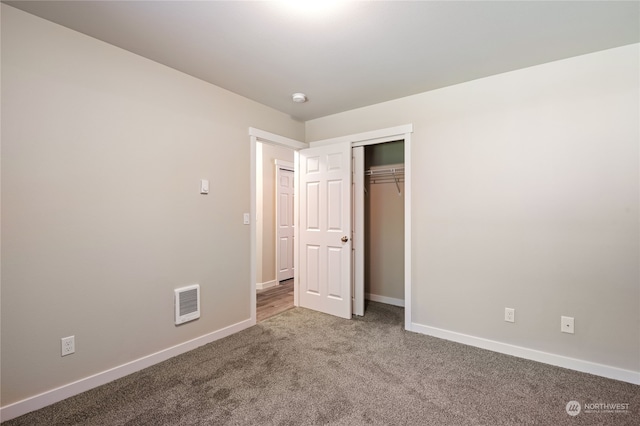 unfurnished bedroom with a closet and carpet flooring