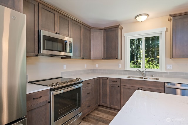 kitchen featuring appliances with stainless steel finishes, sink, and hardwood / wood-style flooring