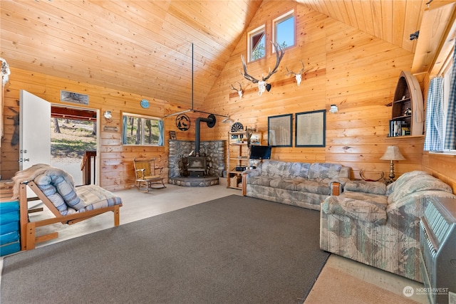 unfurnished living room with carpet, plenty of natural light, a wood stove, wood ceiling, and high vaulted ceiling