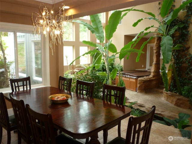 tiled dining area featuring a wealth of natural light and an inviting chandelier