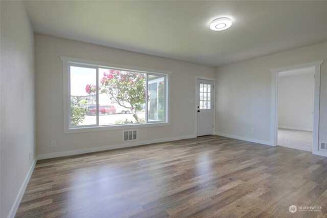 unfurnished room with hardwood / wood-style flooring