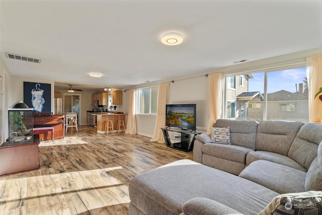 living room featuring ceiling fan and light wood-type flooring