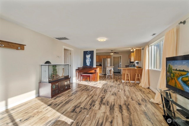 living room featuring ceiling fan and light wood-type flooring