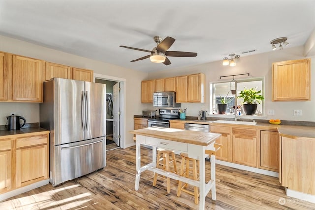 kitchen featuring ceiling fan, sink, light brown cabinetry, appliances with stainless steel finishes, and light wood-type flooring