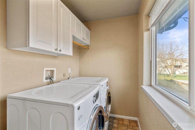 washroom with cabinets and washing machine and clothes dryer