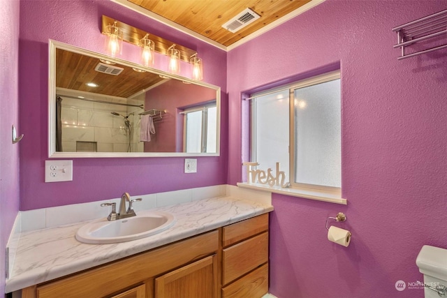 bathroom with tiled shower, vanity, toilet, and wooden ceiling