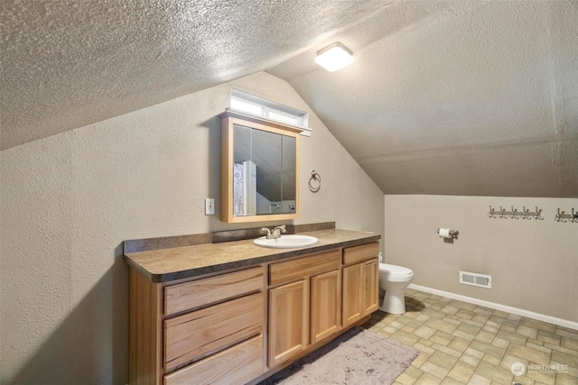 bathroom featuring vanity, toilet, a textured ceiling, and vaulted ceiling