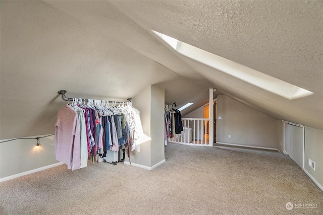 additional living space with lofted ceiling with skylight, carpet, and a textured ceiling