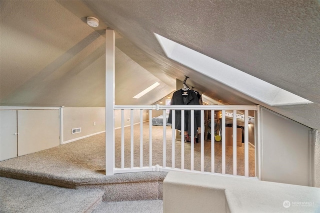 bonus room with vaulted ceiling with skylight and carpet