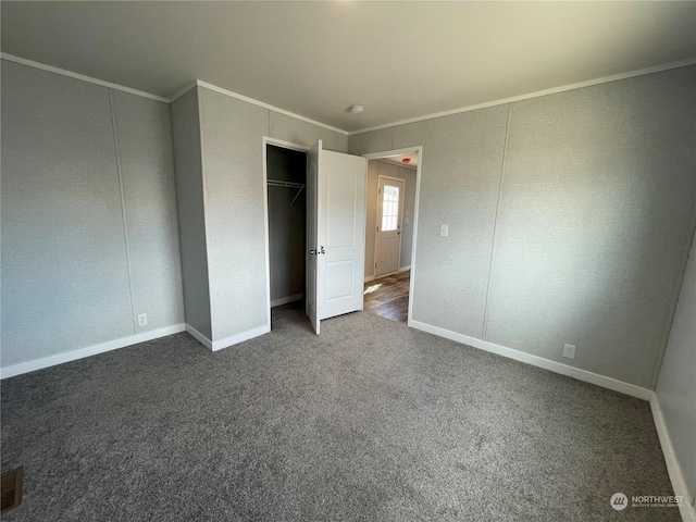 unfurnished bedroom featuring ornamental molding, carpet floors, and a closet