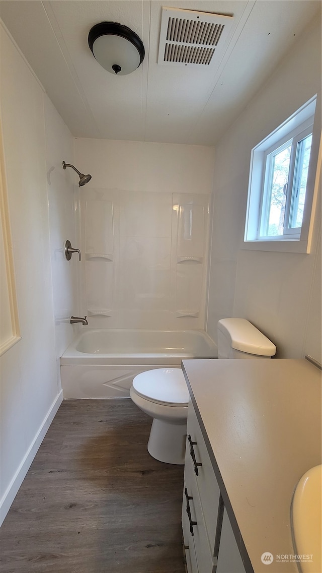 full bathroom with wood-type flooring, bathing tub / shower combination, vanity, and toilet