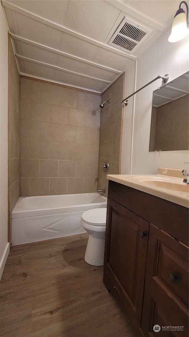 full bathroom with hardwood / wood-style flooring, vanity, and tiled shower / bath