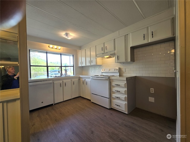 kitchen with tasteful backsplash, dark wood-type flooring, white cabinets, sink, and white appliances