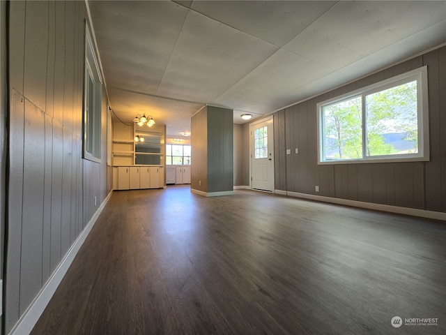 empty room featuring dark hardwood / wood-style floors and wood walls