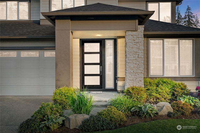 exterior entry at dusk with a garage