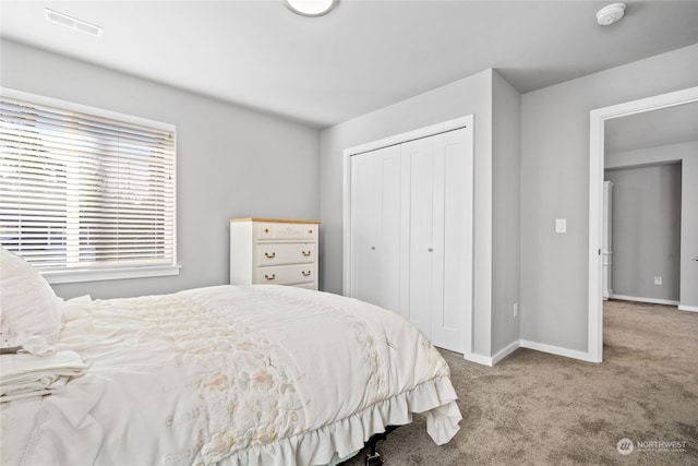 bedroom with light colored carpet and a closet