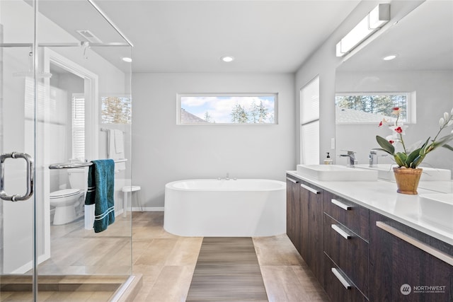 full bathroom with vanity, shower with separate bathtub, and toilet