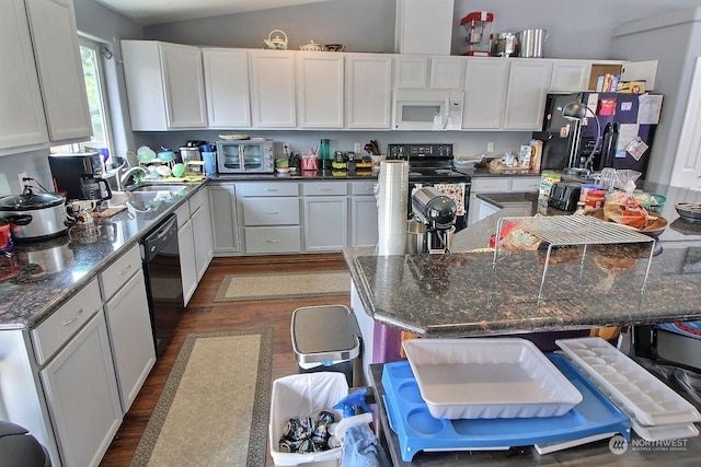 kitchen with black appliances, white cabinets, and dark stone counters