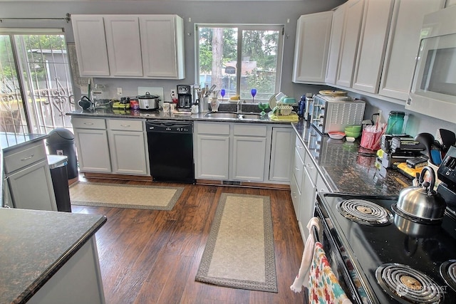 kitchen featuring stainless steel electric range oven, sink, dark wood-type flooring, black dishwasher, and white cabinets