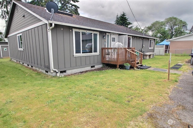 rear view of house with a lawn and a deck