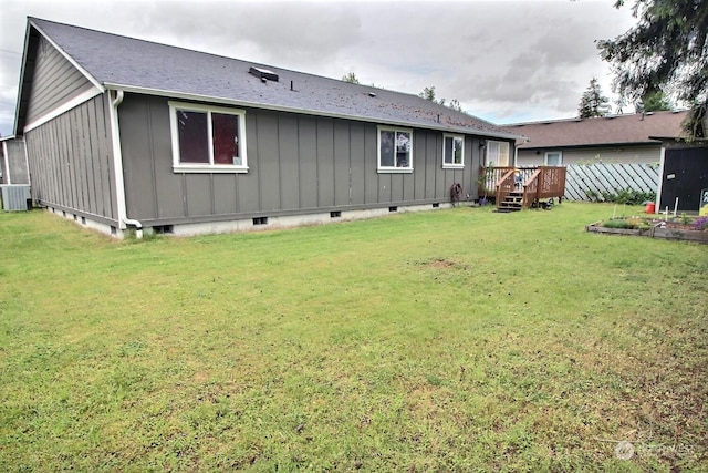 rear view of property with a yard, a deck, and central AC unit