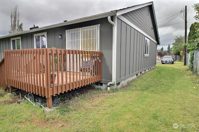 view of side of property featuring a wooden deck and a yard