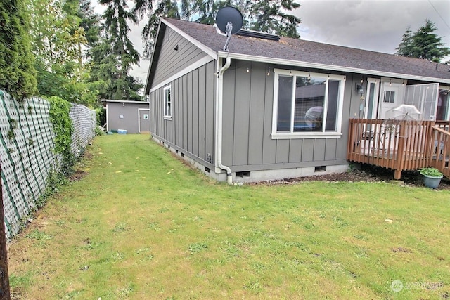 rear view of house with a lawn and a deck