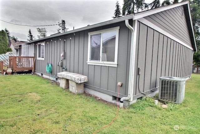 exterior space with a lawn, central AC unit, and a deck