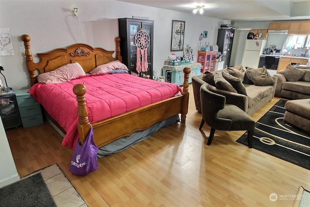 bedroom with white refrigerator and light hardwood / wood-style floors