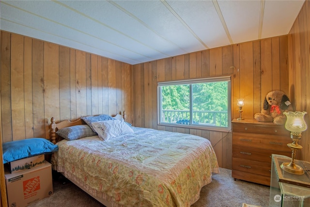 bedroom with wood walls and carpet floors