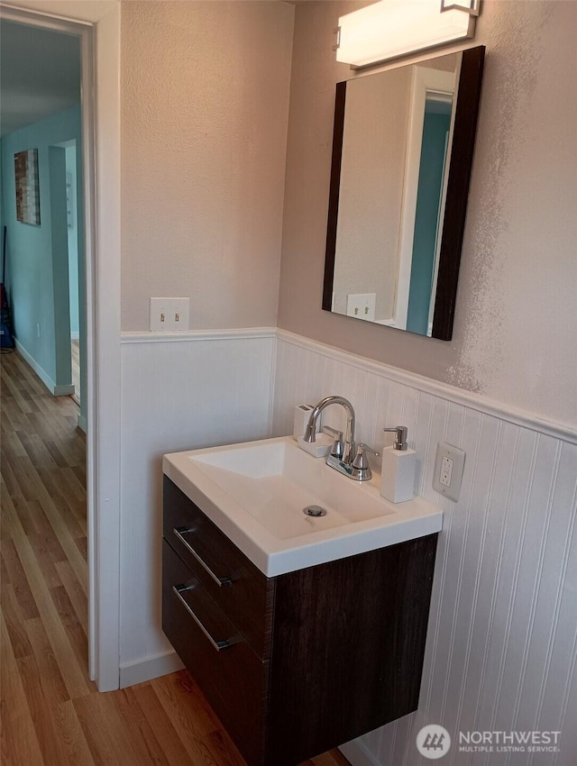 14607 Union Ave SW, Lakewood, WA 98498 - bathroom featuring wood finished floors, a wainscoted wall, and vanity